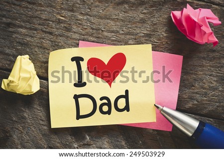 Note with I love Dad. Note with I love Dad and red heart on the wooden background with pen