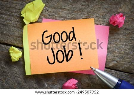 Note with good job! Note with good job!on the wooden background with pen