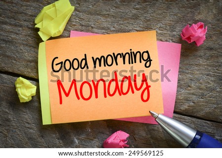 Note with good morning monday. Note with good morning monday on the wooden background with pen