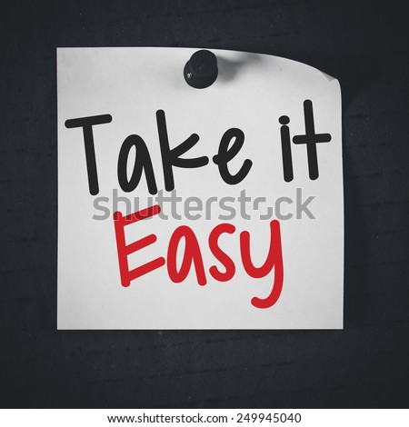 Note with take it easy. White stick note paper with take it easy on blackboard background