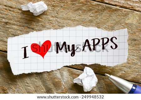 I love my apps Note. Note with I love my apps and red heart on the wooden background with pen