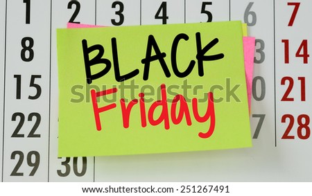 Black friday on calendar background. The phrase Black friday on sticky paper note stuck to a wall calendar background