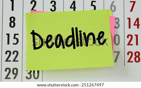 Deadline on calendar background. The phrase Deadline on sticky paper note stuck to a wall calendar background
