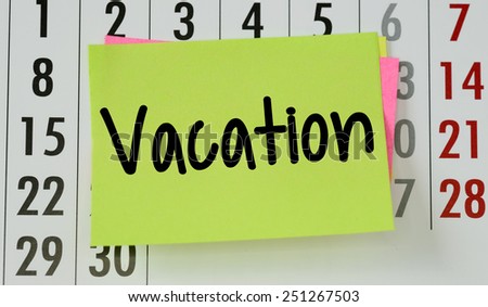Vacation on calendar background. The phrase vacation on sticky paper note stuck to a wall calendar background