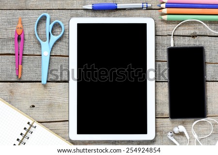 Tablet pc and office supplies. Empty tablet pc and office supplies on wooden background