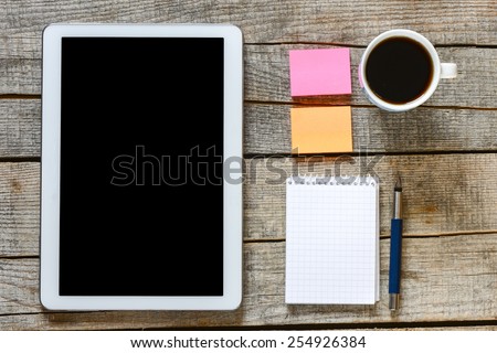 Empty tablet pc and coffee. Empty tablet, notebook, pen and a coffee on wood table