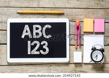 Tablet pc and school supplies. ABC 123 on Tablet pc and school supplies on wood table