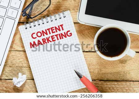 Notebook with content marketing. Workplace with keyboard , tablet pc , coffee, notebook with content marketing and pen on wood table