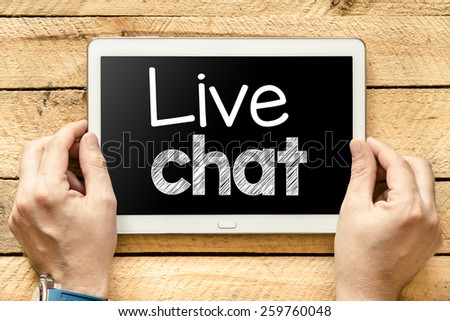 Tablet pc with live chat. Male hands holding tablet pc with live chat on wooden background