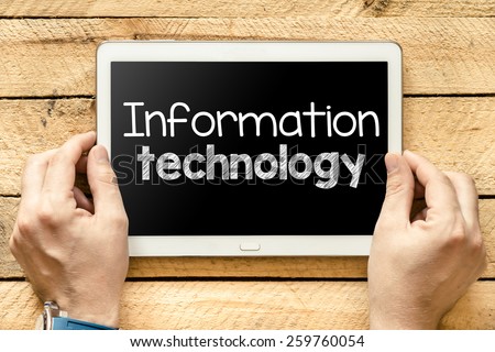 Tablet pc with information technolog. Male hands holding tablet pc with information technology on wooden background