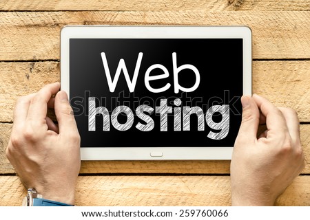Tablet pc with web hosting. Male hands holding tablet pc with web hosting on wooden background