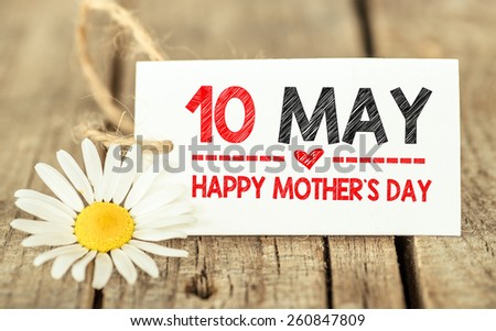 10 May, happy Mother\'s day on label. Flowers and label with Happy Mother\'s day on wooden background.