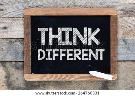 Think different Sign. Think different Sign on blackboard on wooden background