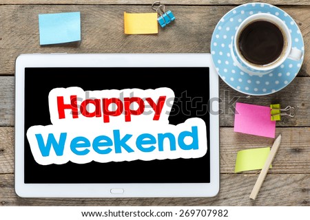 Happy weekend on Tablet computer. Tablet computer with stickers,cup of coffee and happy weekend on the wooden table