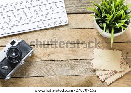 Old camera with keyboard. Old camera with keyboard and green plant on wooden background