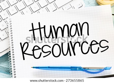 Notepad with human resource and keyboard on wooden background