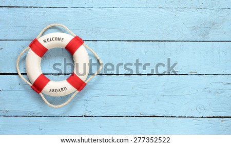 Lifebuoy with Welcome on Board phrase on wooden background