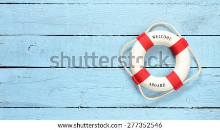 Lifebuoy with Welcome on Board phrase on wooden background