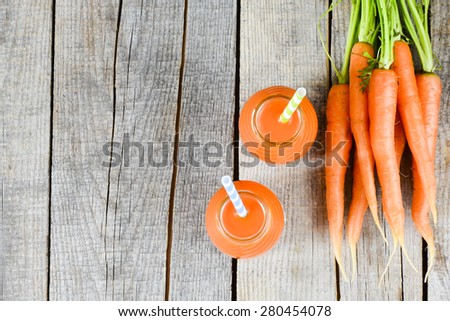Carrots and carrots juice. Healthy food - carrots and carrots juice on wooden background