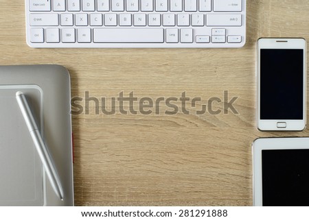 Tablet pc ,smart phone,Pen tablet and keyboard on wooden background