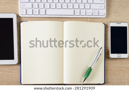 Tablet pc,mobile phone ,notebook And keyboard on wooden background