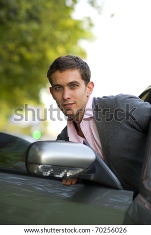 Handsome man sit down to his car
