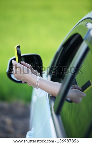 woman\'s hand using smart phone outside window car,conceptual for holiday,relax,navigator.