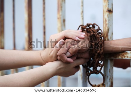 women hand holding prisoner hand.