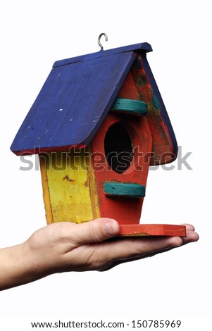 hand holding colorful bird house isolated on white background