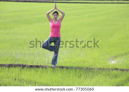 girl practicing yoga,standing with paddy field background