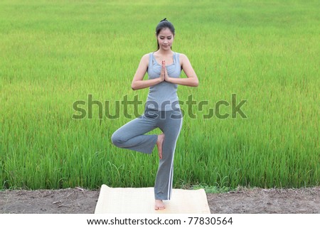 girl practicing yoga,standing with paddy field background