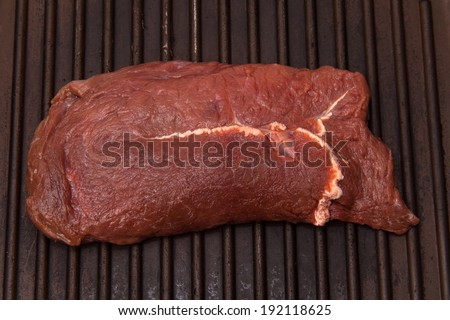 Horse meat steak cooking on a griddle