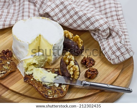 Cheese board with French cheese, crackers and dates