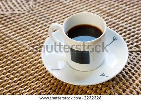 White cup of coffee in rattan table