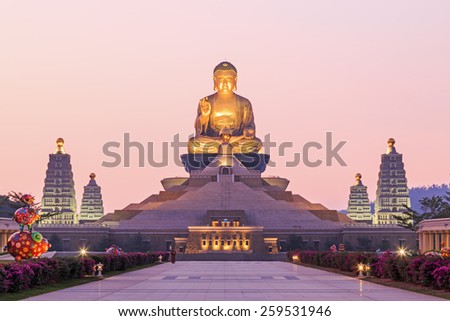 Kaohsiung, Taiwan - December 15, 2014: Sunset at Fo Guang Shan, the biggest buddist temple of Kaohsiung in Taiwan, with a buddhist monk walking by.