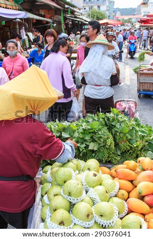 Kaohsiung, Taiwan - June 22,2015: People selling and buying food in a traditional fruit and vegetable market of Taiwan