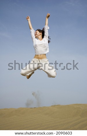 girl jumping for joy from the dunes in Maspalomas in Gran Canaria