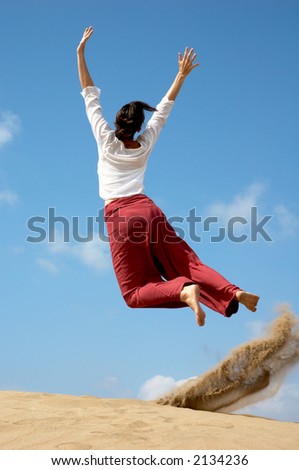 Girl jumping for joy from the dunes in Gran Canaria