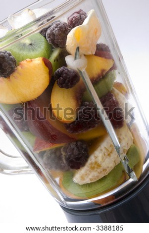 glass blender filled with a selection of healthy fruits and ice ready to make a smoothie