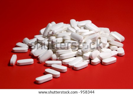 White pills on red background