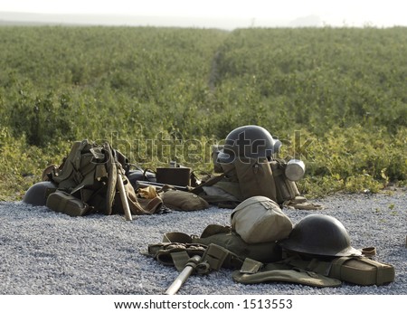 World War I British army helmets and kits lying on the ground in front of a field in the Somme region in northern France, scene of WWI's bloodiest battle.