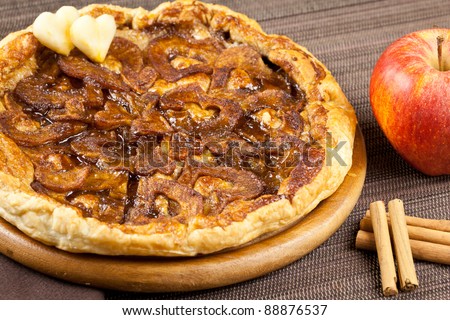 Apple tart with two heart shapes, cinnamon sticks and apple