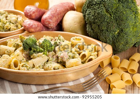 Traditional Italian macaroni pasta with broccoli, potatoes and sausage. Served in a terine and surrounded by raw ingredients