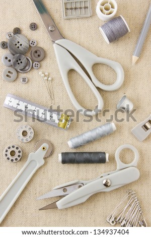 A collection of sewing, needlecraft, dressmaking, tailoring tools and items in harmonizing neutral grays and beige