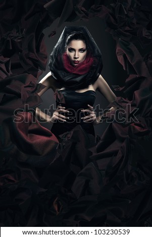 mysterious woman in black hood in dark fabric