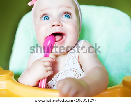 little child with pink spoon in mouth