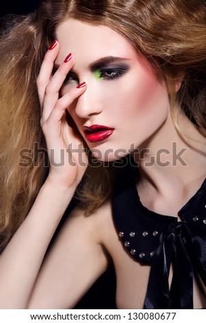 Blonde woman with hand on her face on dark background