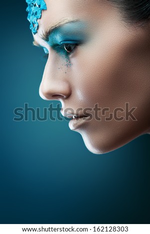 woman with blue stones on face