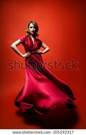 Woman in a flowing red dress on red background