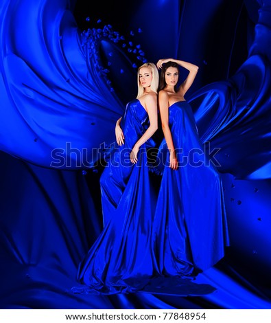two women in blue dress with long hair and hearts  on red drapery